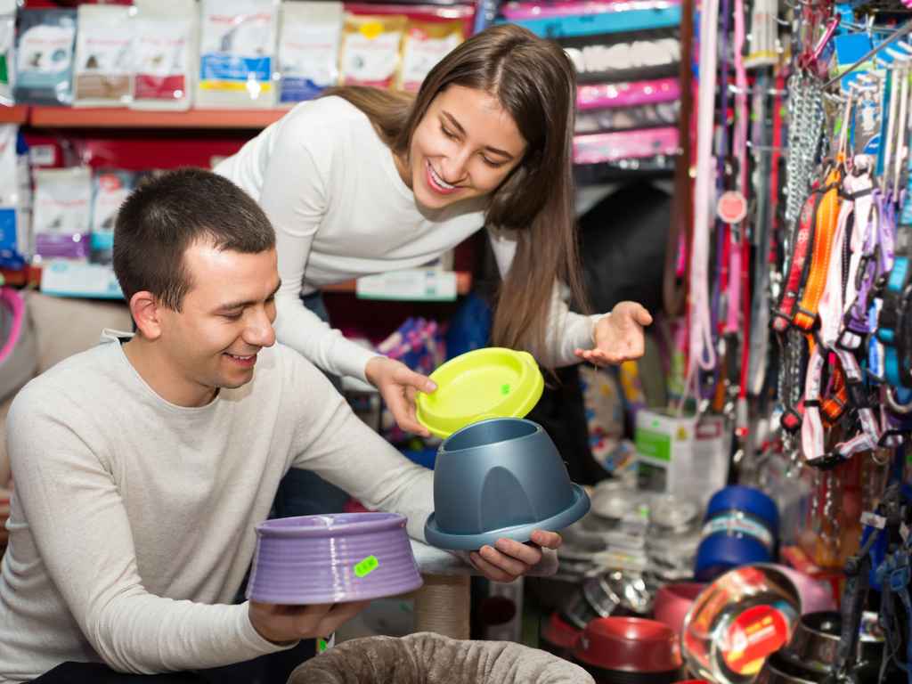 pessoas no pet shop pegando recipientes de ração