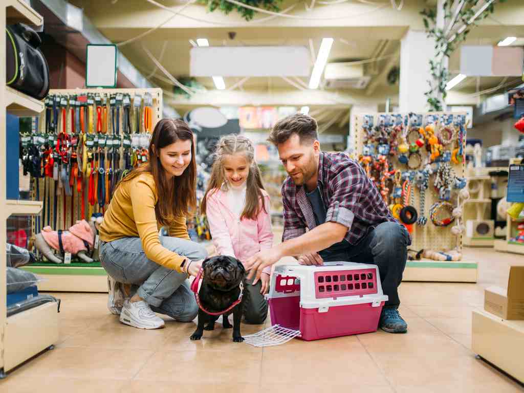família no pet shop fazendo carinho no cachorro