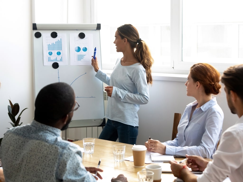 colaboradores em uma sala falando sobre números de venda