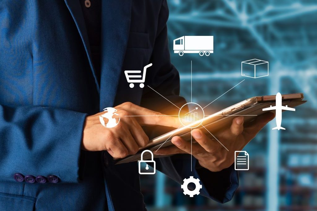 Foto de um homem de negócios segurando um smartphone e do smartphone saem diversos icones de transporte como avião, onibus, carro.